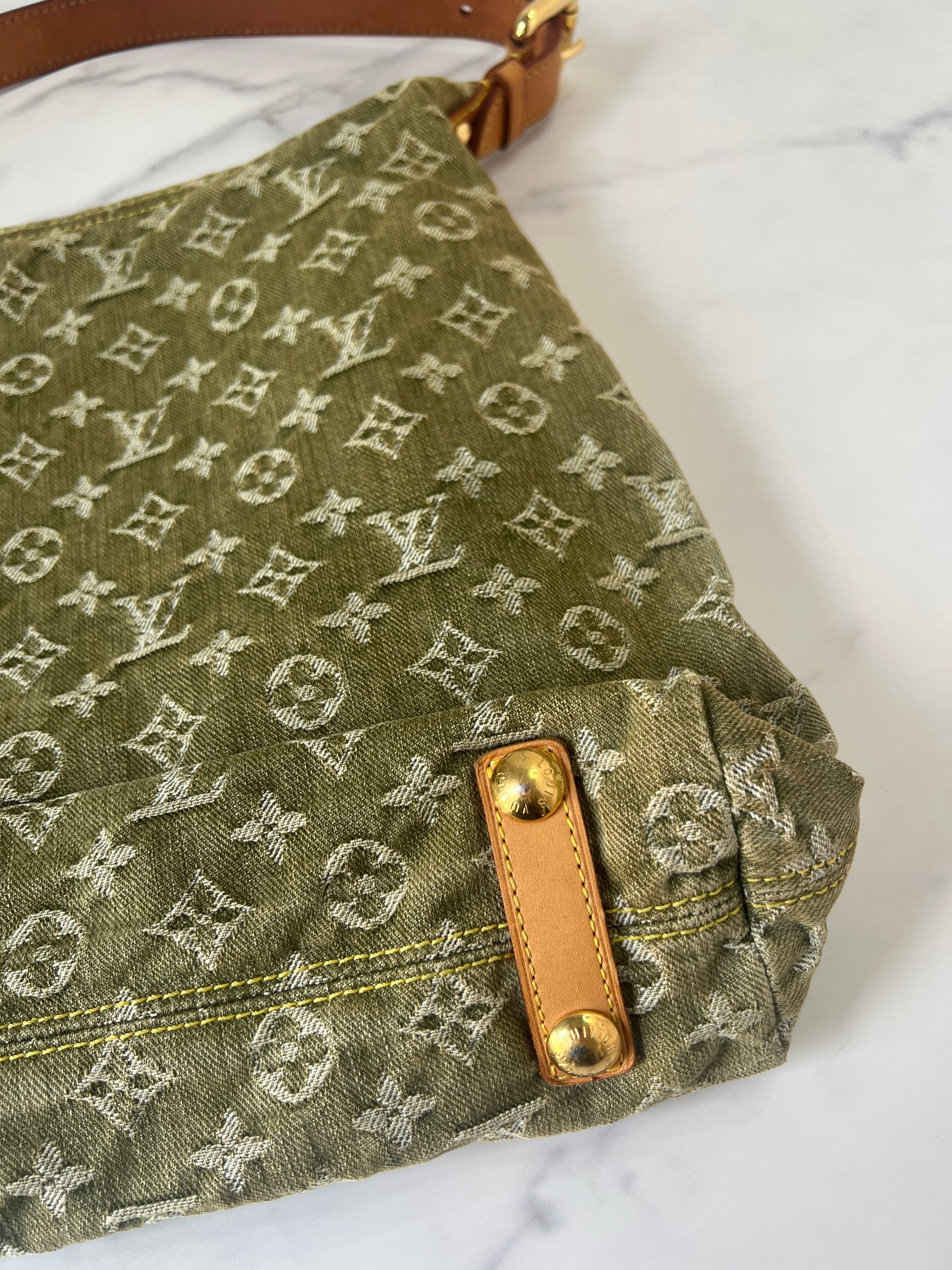 Bottom right corners of Louis Vuitton Baggy GM in green monogram denim